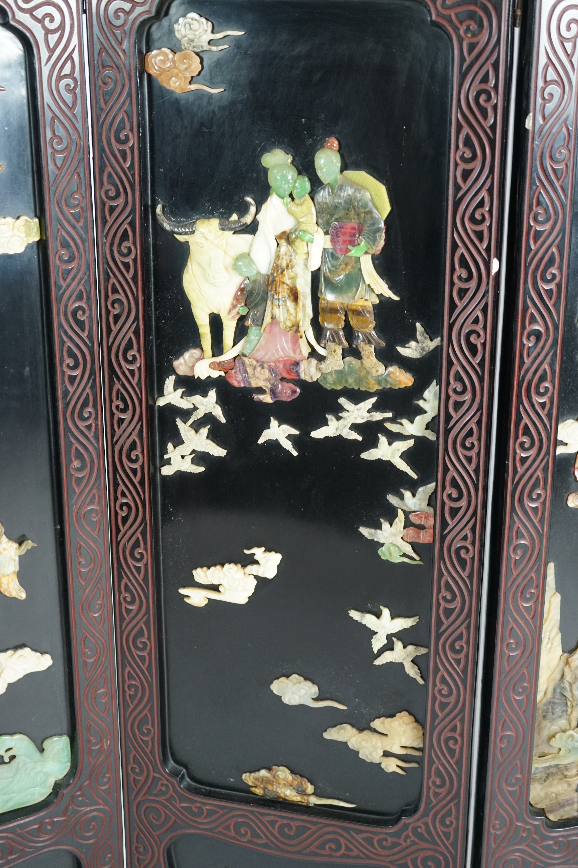 A Chinese tixi lacquer and carved soapstone overlaid six panel screen, mid 20th century